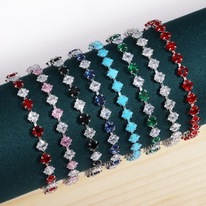 Macro view of tennis bracelets with colorful square zircons on green velvet display
