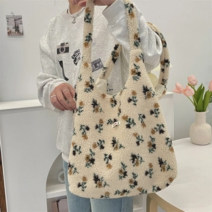 Detail of floral plush tote bag made of off-white faux shearling with brand label