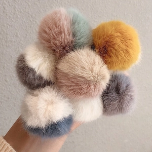 Dettaglio ravvicinato di morbidi pompon di peluche colorati per accessori per capelli
