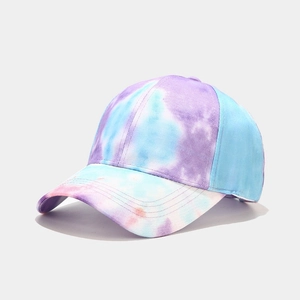 Detailed close-up of a tie-dye baseball cap in pastel purple, blue, and white cotton fabric