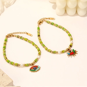 Dettaglio di braccialetti con perline Evil Eye con perle dorate e ciondoli in smalto