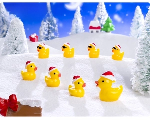 Miniature Christmas ducks with Santa hats and sunglasses on a snowy landscape background