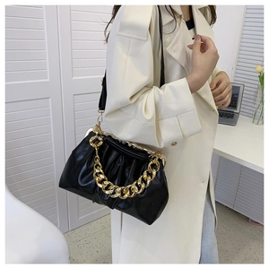 Detail of black pleated shoulder bag with chunky gold chain strap and smooth oil leather finish