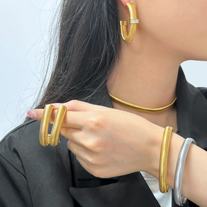 Detailed look at gold and silver Tubogas jewelry set worn by model for elegant style