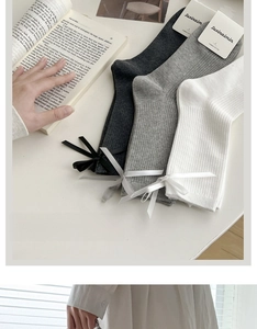 Three pairs of combed cotton bow socks in black, grey, and white with ribbed texture