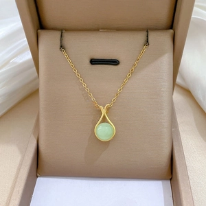 Detail of gold lucky bag necklace with green jade gemstone and micro diamond pavé