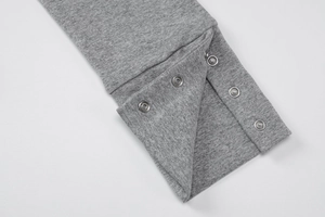 Detail of metal snap button closure on grey knit fabric for slim fit cardigan