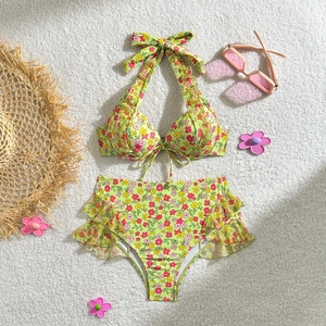 Détail de haut de bikini fleuri avec bretelles à volants et nœud au dos sur tapis