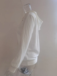 Detalle del suéter con capucha blanco con textura de punto acanalado y manga larga