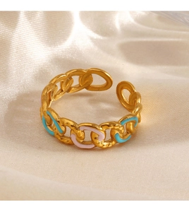 Macro shot of gold chain ring with blue and pink enamel on soft white silk backdrop