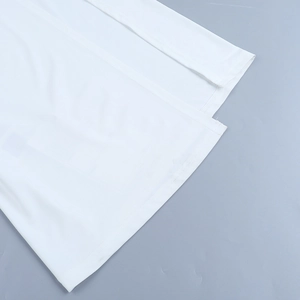Detail shot of high-quality stitching and fabric texture on white beach vacation dress