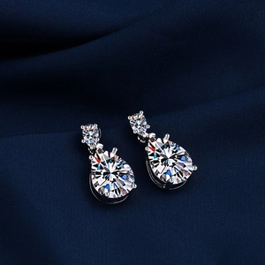 Macro shot of silver pear-cut teardrop earrings with multi-prong moissanite settings