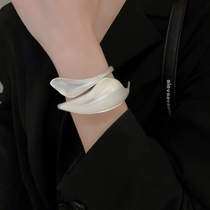Macro shot of silver matte leaf-shaped cuff bracelet with satin finish on model
