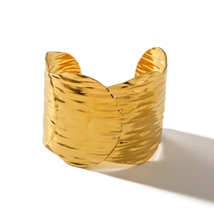 Polished 18k gold plated stainless steel open bangle with wave texture on white background