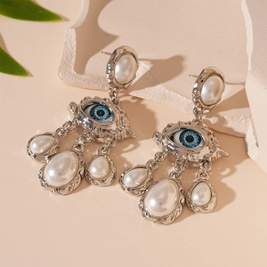 Vue détaillée de boucles d'oreilles œil porte-bonheur avec perles sur socle pierre