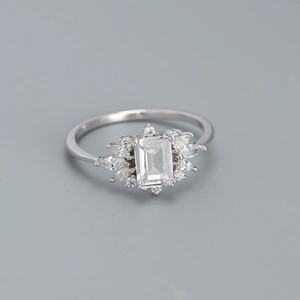 Macro shot of silver ring featuring large emerald cut stone and marquise halo detail