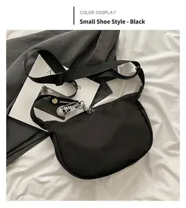 Detail of black nylon crossbody bag with adjustable strap and daisy flower charm accessory