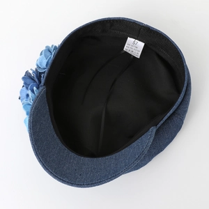 Blue denim flower beret with cotton lining and size label detail on white background