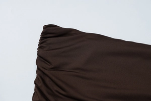 Detail shot of deep brown ruched fabric showing high-elasticity knit texture and seams
