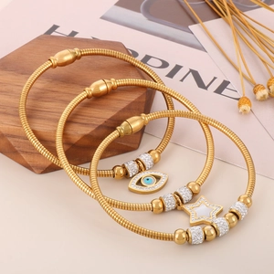 Gold snake chain bracelets set with evil eye and star charms and sparkling crystals