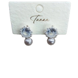 Elegant purple pearl stud earrings with zircon floral accents on a display card