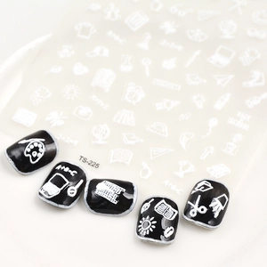 Detail of 5D white school themed nail stickers with palette and math patterns on black nails