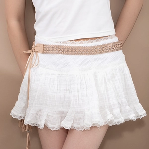 Détail de jupe blanche en dentelle superposée avec ceinture à franges ajourée beige