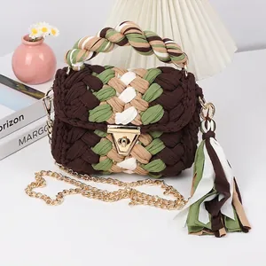 Detail of handmade crochet shoulder bag with colorful fabric tassel and metal chain