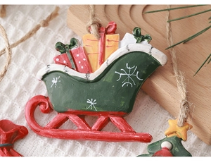 Close-up of a festive green resin Christmas sleigh ornament with colorful gift boxes