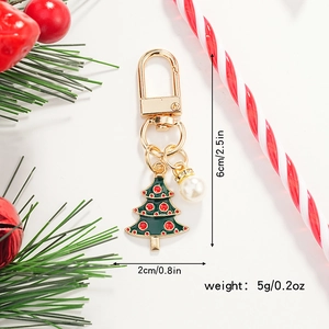 Detail of Christmas tree keychain with gold clip and white pearl on festive background