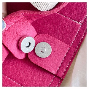Detail of magnetic silver snap closure and precise stitching on rose red felt tote bag