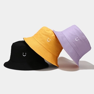 Three cotton smile face bucket hats in black, yellow and purple for sun protection