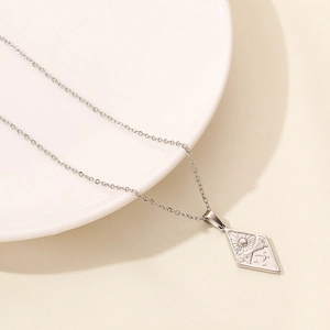 Detail of silver stainless steel diamond pendant with celestial moon and star engravings