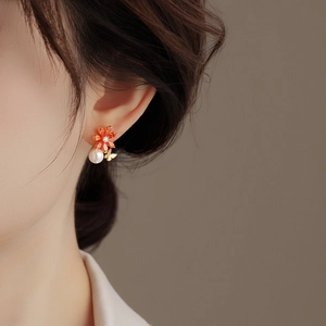 Boucles d'oreilles élégantes avec fleurs orange, perles et détails de papillon doré