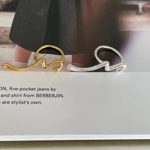 Minimalist 925 silver fluid abstract rings in gold and silver finish on book page