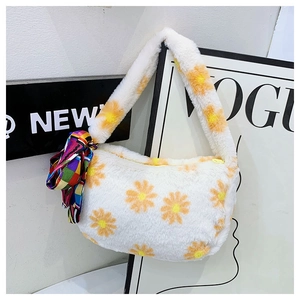 Detailed close-up of soft plush handbag with orange daisy print and decorative silk scarf