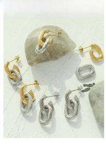 Macro shot of oval gold and silver earrings with unique spiral embossed texture details