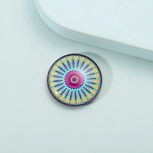 Close-up of a round mandala pattern fridge magnet with colorful crystal glass finish