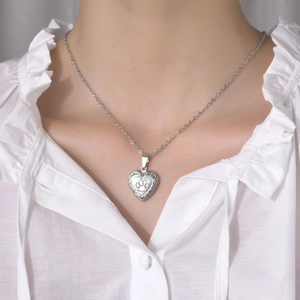 Detail of silver heart locket necklace with paw print engraving on stainless steel