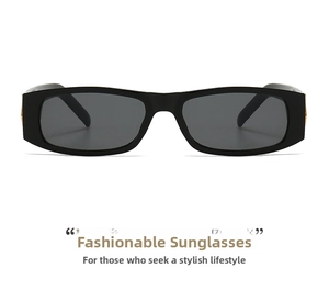 Detailed close-up of black rectangular sunglasses with golden metal hinges and dark grey lenses