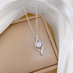 Macro shot of silver titanium necklace with micro-pave pendant on beige jewelry box
