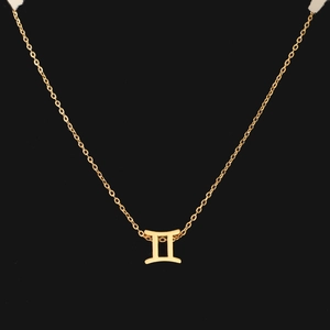 Macro shot of gold Gemini zodiac sign pendant necklace on a sleek black background