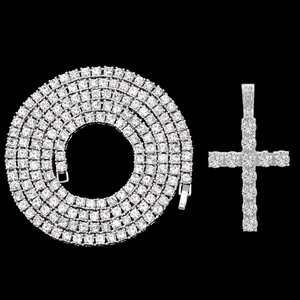 Macro detail of silver tennis chain with cross pendant and sparkling zircons