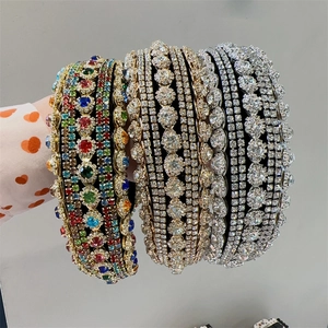 Detailed view of hand-held baroque headbands with colorful rhinestones and gold plating