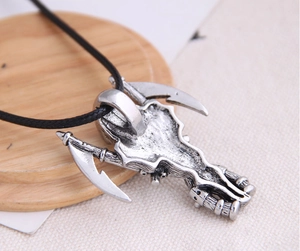 Macro view of gothic silver skull and crossed scythes pendant on black cord necklace