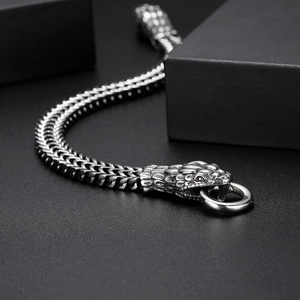 Close-up of punk style stainless steel bracelet featuring a detailed serpent head clasp