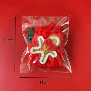 Handmade chenille gingerbread man crochet pendant with size specs on red background