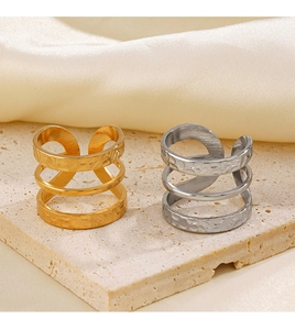 Detail of layered gold and silver rings with hammered texture on a stone surface