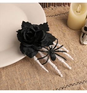 Detail of Halloween hair clip with black rose, white skeleton hand and spider on burlap