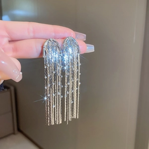 Close-up of sparkling silver tassel earrings with delicate diamonds and starburst effect